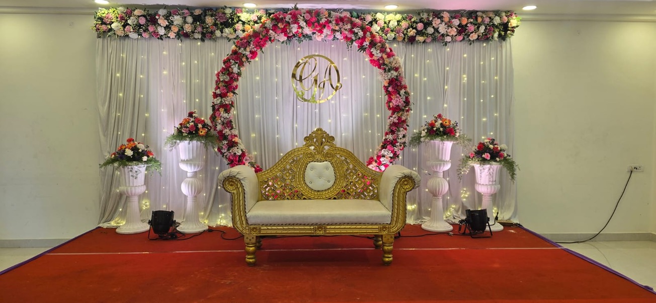Reception stage with floral ring arch, fairy-light backdrop and gold sofa at VJK Mahal, Pallavaram Chennai